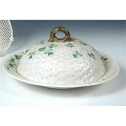 An early 20th century Belleek muffin dish and cover, the latter domed, basket moulded and painted w.