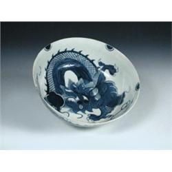 A 18th century blue and white bowl, possibly Liverpool, boldly painted with dragons chasing the fla.