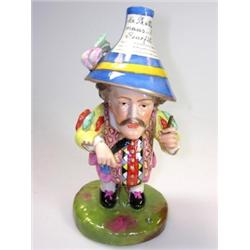 A Derby style Mansion House dwarf, the label in his blue hat reading 'Mr Prettyman's Benefit', he w.