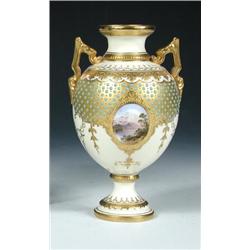An early 20th century Coalport jewelled vase, the waisted neck and gilt handles raised above the tu.