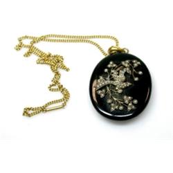 A Victorian oval black locket applied with a pearl set bird in a branch, with photo back, 60mm, sus.