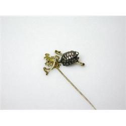 A Chinese gold stock pin with character terminal linked to a pin brooch mounted with the figure of..