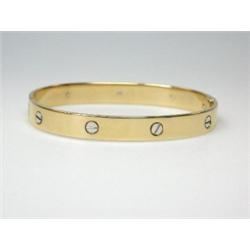 A gold hinge bangle, plain but decorated with screw heads all round, 6.5cm diameter   £350-450...