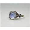Image 1 : A white metal moonstone ring mounted with a spherical stone above foliate shoulders set with tiny s.