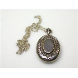 A Victorian silver locket, Birmingham 1892, of oval shape, the front embossed with a laurel wreath..