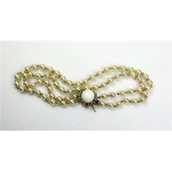 A double string cultured pearl necklace with gold bead spacers and a 14ct gold clasp set with pale..