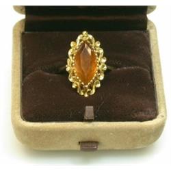 A gold dress ring mounted with a marquise topaz coloured stone in a scrolled setting    £50-80...