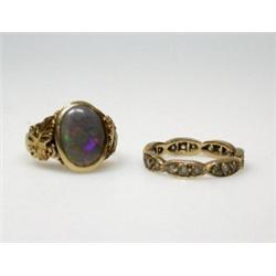 A gold and opal ring set with an oval cabochon stone above leaf shoulders and a 9ct gold eternity r.