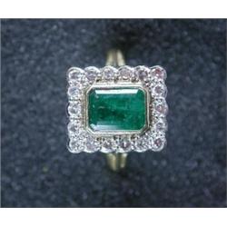 An 18ct gold emerald ring the oblong stone within a surround of modern brilliant cut diamonds   £2,.