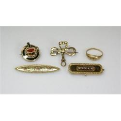 A small circular brooch set with bloodstone and other agates with a shield within a ribbon surround.