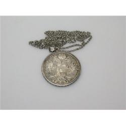 A silver Marie Theresa Thaler coin, restrike, contained in a loose pendant mount on a silver belche.