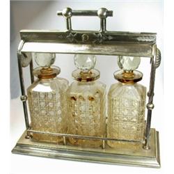 An electroplate three bottle tantalus, raised on a plain square base below a patent rolling bar loc.
