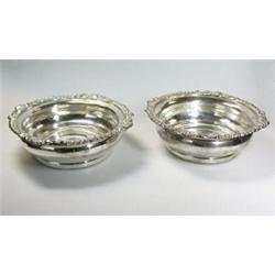 A pair of Old Sheffield plate wine coasters of compressed circular form with shell and foliate gadr.