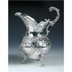 A Portuguese silver jug, marked for Opporto, circa 1905, the body pear shaped and embossed with scr.