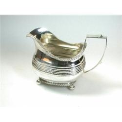 A George III silver cream jug by Simon Harris, London 1810, of compressed rectangular shape, raised.