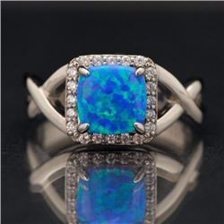 A sterling silver .925 and synthetic blue opal bypass ring.