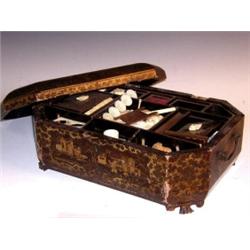 A mid Victorian Chinese lacquer work box, the canted rectangular lid gilt with figures on a black g.