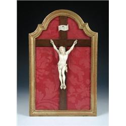 An early 20th century Dieppe ivory crucifix, the figure of Christ nailed to a mahogany cross labell.