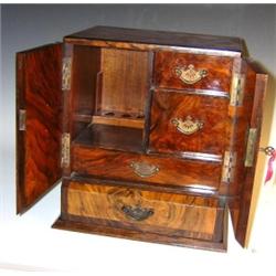A 19th century burr walnut smoker's cabinet edged in ebony line, the doors opening above a drawer a.