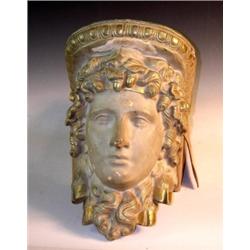 An early 20th century gilt and painted plaster wall bracket cast as a classical head adorned with a.
