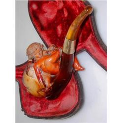 An early 20th century meerschaum pipe, the bowl carved with an amorini holding two cherries while a.