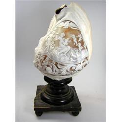 An early 20th century cameo carved conch shell lamp, a lady in diaphanous robes is seated below a n.