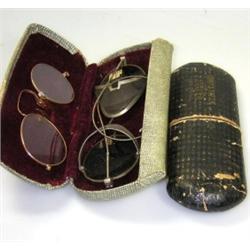 A pair of pince nez in yellow metal frames together with a pair of dark glasses with steel mesh sid.