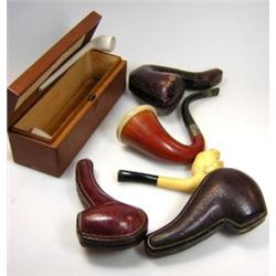 A collection of five meerschaum pipes and two clay pipes, one of the former carved as a military ma.