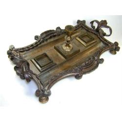 An early Victorian bronze inkwell, the shaped rectangular tray with two foliate handles, the pen tro