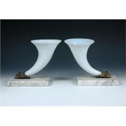 A pair of early 19th century opaline glass cornucopiae, the horn shapes held in ormolu ram's heads..