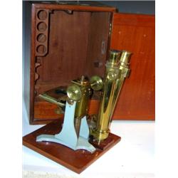 An early 20th century mahogany case brass binocular microscope, the stage with celluloid millimetre.