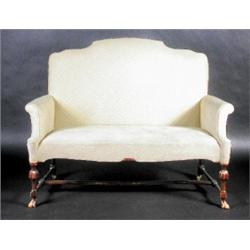 An 18th century style walnut framed settee, the arched padded back above scrolling arms and overstu.