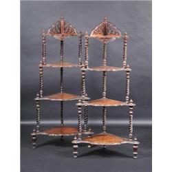 A pair of Victorian walnut whatnots, each with pierced gallery above four conforming tiers supporte.