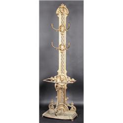A cast iron hall stand, the pierced back incorporating hooks above a two division umbrella stand, s.