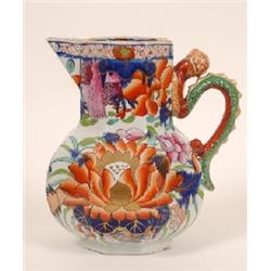 A 19th Century Ironstone Jug, decorated flowers, with serpent handle, (a.f.) 23 cm See illustration