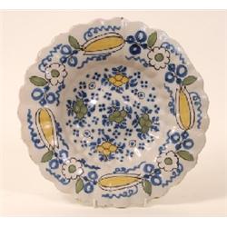 A Dutch Delft Scalloped Dish, decorated flowers and fruit, (a.f.) 33 cm See illustration