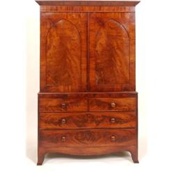 An Early 19th Century Mahogany Linen Press, with a pair of arched doors enclosing five slides, above