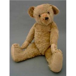 A large blond mohair teddy bear, straw-stuffed, with cloth paws and black glass eyes, slight wear...