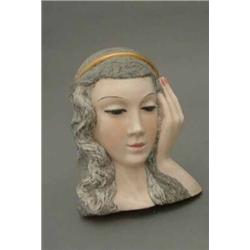 A Goldscheider style face mask, in slip pottery, modelled as a Madonna with blue eyes, one hand r...