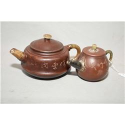 Two purple clay Oriental teapots, each one with jade spout, finial and handle and both are engraved 