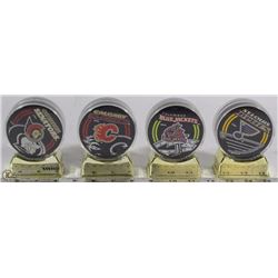 SET OF 4 NHL INCASED HOCKEY PUCKS ON STAND