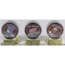 SET OF 3 NHL INCASED HOCKEY PUCKS ON STAND