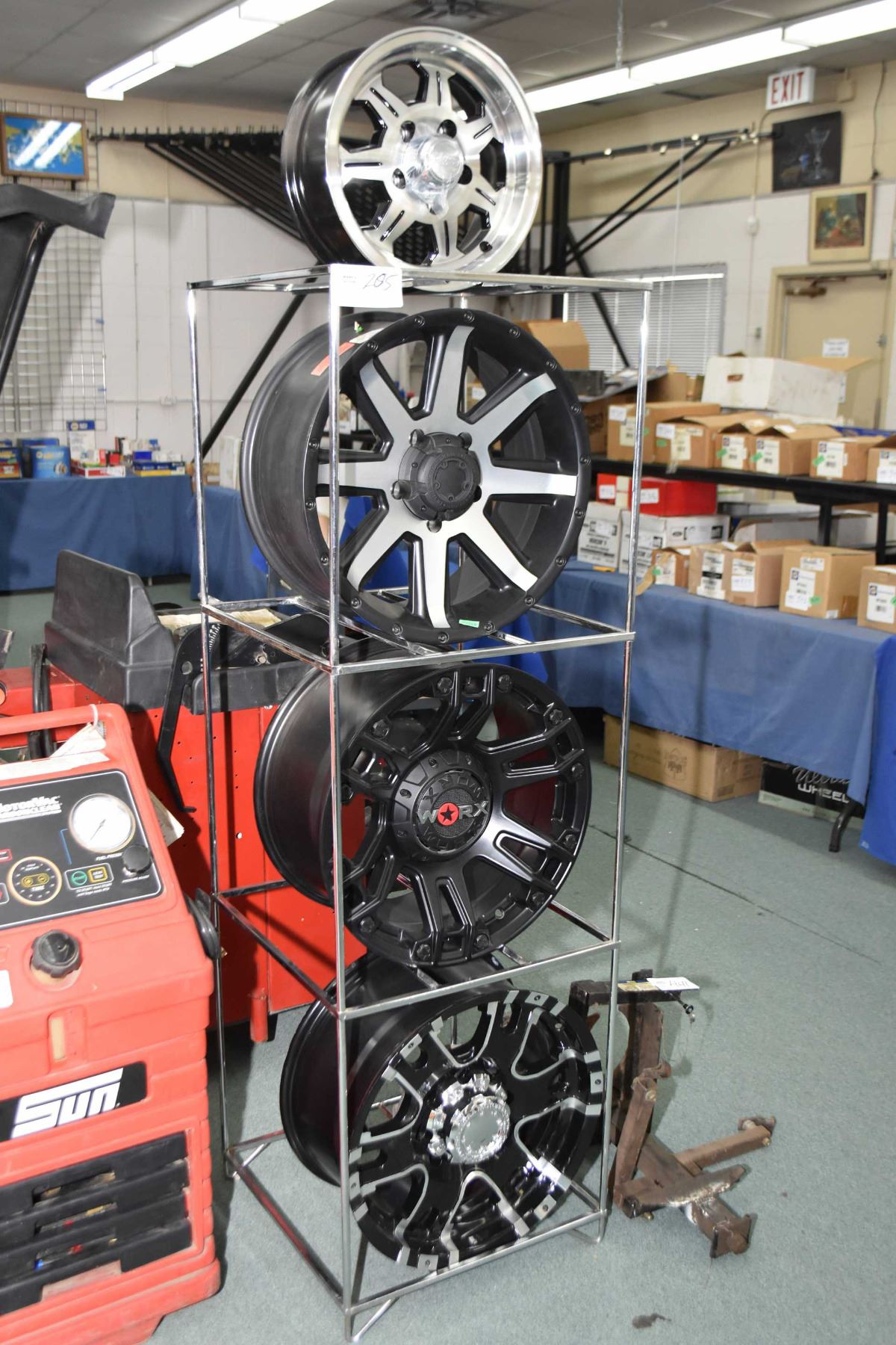 Chrome four tier showroom display rack with four custom mismatched rims ...
