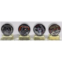 SET OF 4 NHL INCASED HOCKEY PUCKS ON STAND