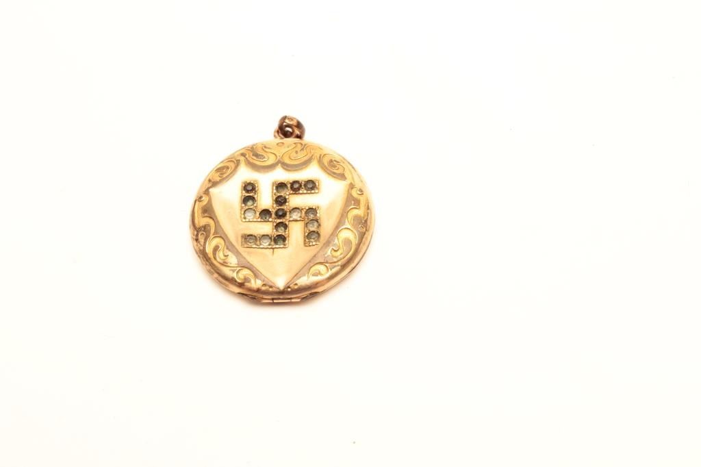 Yellow metal locket with Indian symbol. The locket is inscribed inside ...