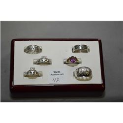 Six sterling silver rings including two Claddagh rings
