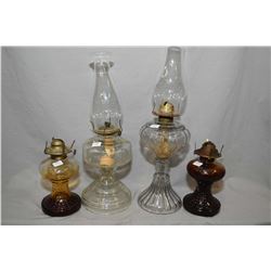 Four vintage oil lamps including a pair of amber glass and two colourless lamps with chimneys