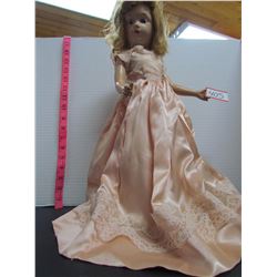 18 inch tall vintage doll in peach dress on stand