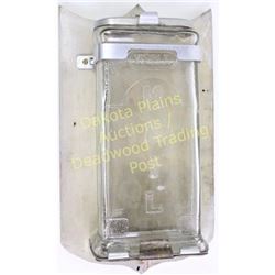 Antique visible glass mailbox embossed MAIL on front and mounted to board, complete with lids top an