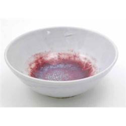 A Ruskin high fired bowl, the centre with shades of blue, turquoise and crimson on a pale grey gr...